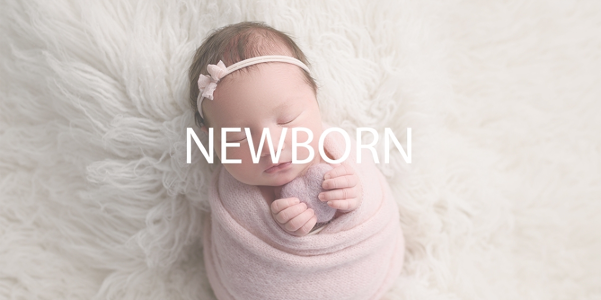 Okotoks AB newborn photography of a newborn baby wrapped in a pink blanket and wearing a pink headband